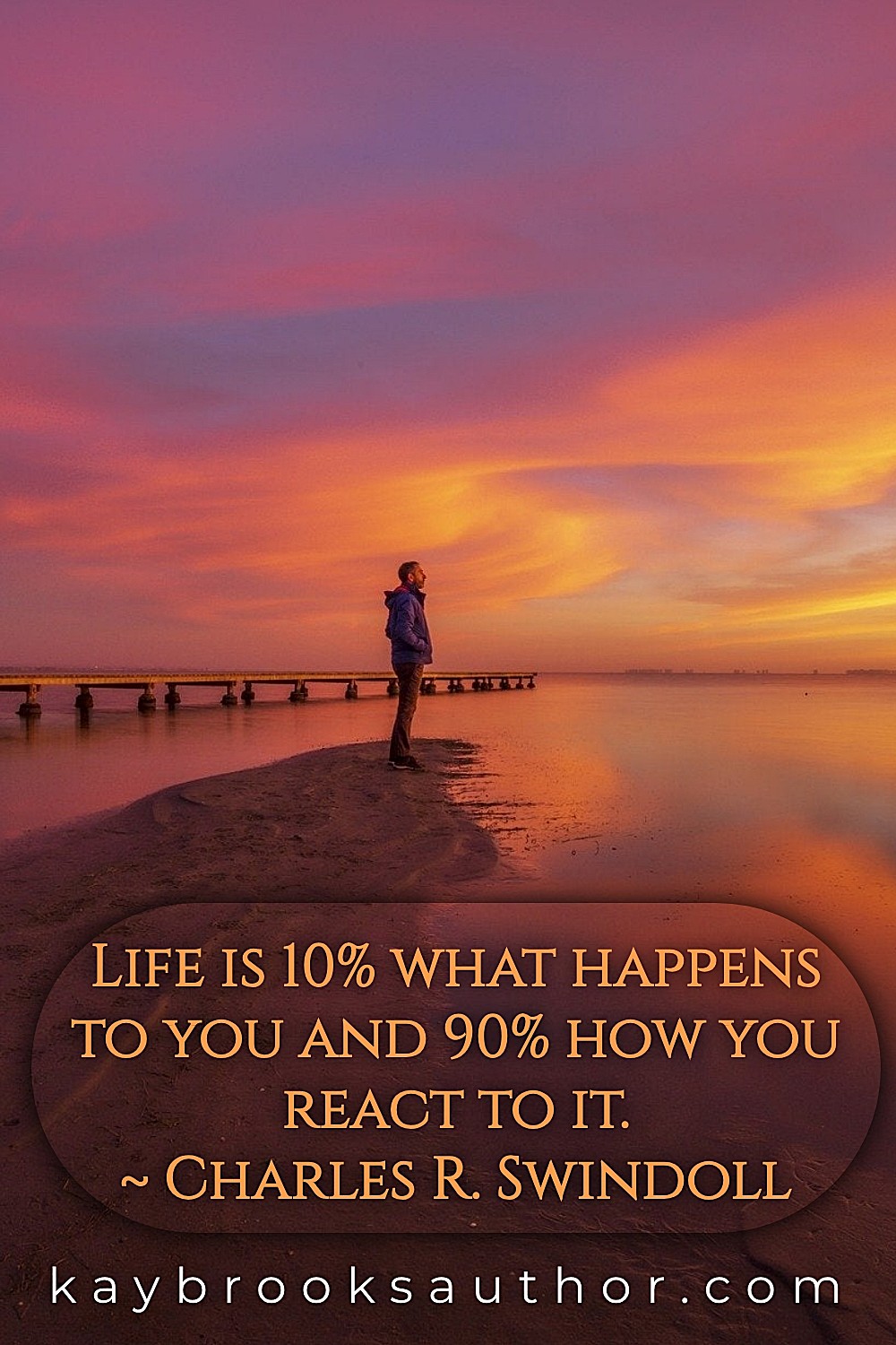 Dramatic fiery orange and gold sunset reflecting over calm water with a solitary figure standing at the shoreline in silhouette, with Charles R. Swindoll's quote 'Life is 10% what happens to me and 90% of how I react to it' displayed in elegant gold serif text on a semi-transparent dark rounded overlay, and kaybrooksauthor.com featured in the footer.